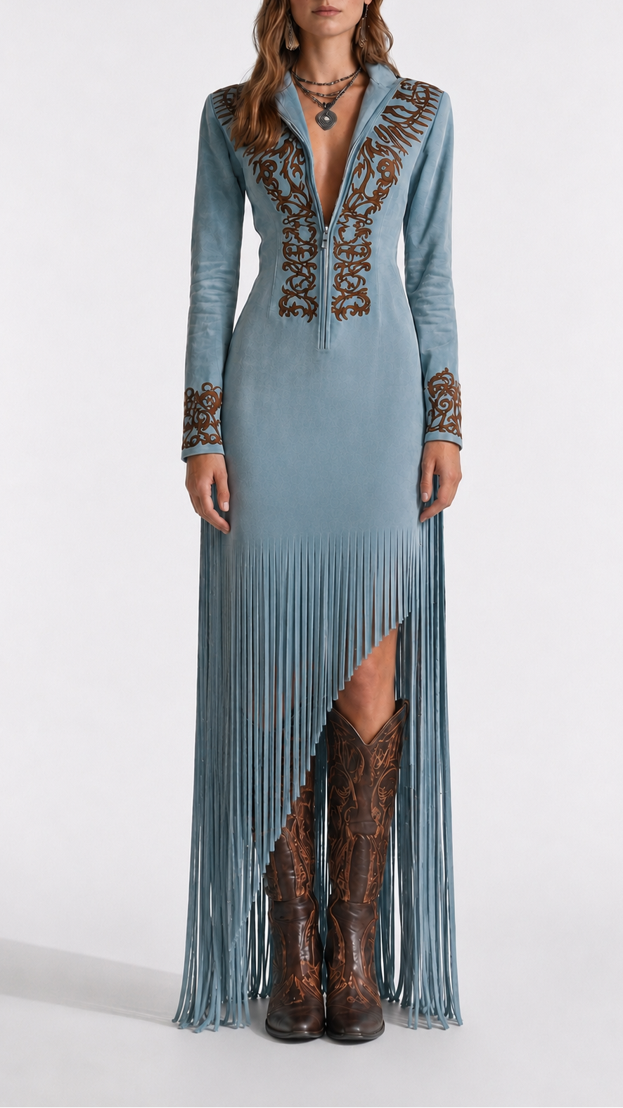 Long blue dress with intricate patterns and fringe, paired with brown boots on a white background
